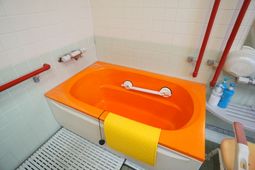 オレンジ色の浴槽と手すり