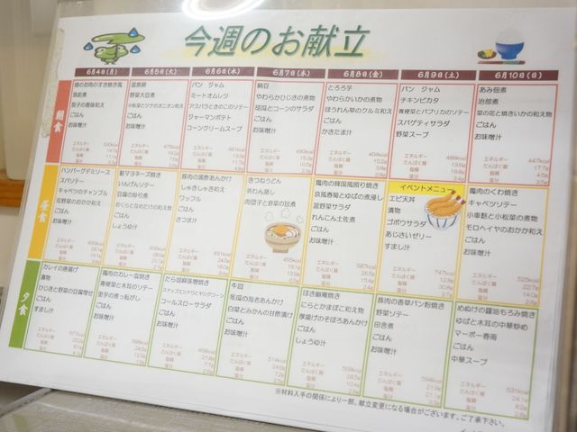 献立案内掲示物 献立表 健康に配慮したバランスの取れたメニューが整理された掲示板があります。食事の楽しみが毎日の暮らしを豊かに彩ります。
