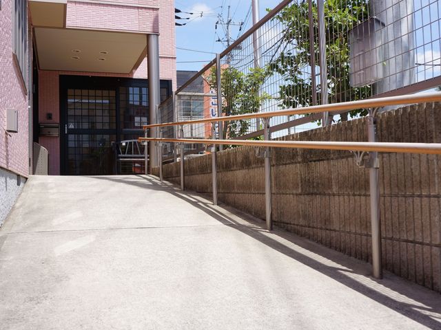 バリアフリー設計のエントランス 玄関 手すりが整備された安全なエントランスです。誰もが快適に出入りできる工夫がなされています。