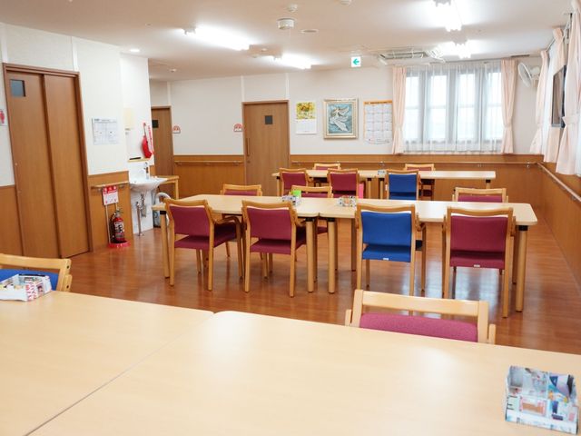明るい食堂の様子 リビング ゆったりとした食堂は、木製のテーブルと色とりどりの椅子が置かれ、落ち着いた雰囲気を醸し出しています。窓からは自然光が差し込み、明るく開放的な空間で食事が楽しめそうです。