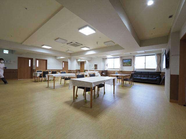 広々とした明るい食堂 ダイニング 広々としたエリアはゆとりある食事時間を提供し、ソファでのくつろぎも楽しめます。スタッフの方が行き交い、温かな雰囲気が漂っています。