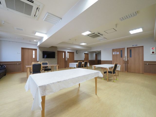広々とした明るい食堂 ダイニング ゆったりとした食堂は、温かみのあるテーブルセットが配置され、テレビも備え付けられており、居心地の良い空間です。