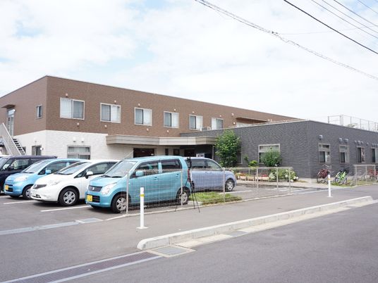 施設の写真 全体的にモノトーンで抑えられた外装に、あちらこちらに植えられた植物の緑が綺麗に映える。自転車置き場も整備されている。