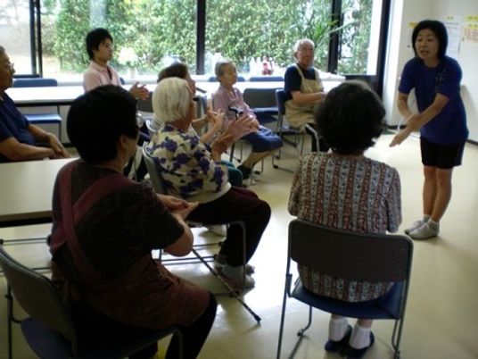 椅子に座る人々と指導者