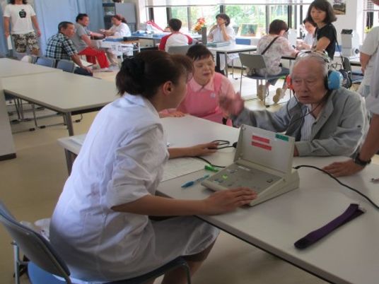 検査を受ける高齢者と職員