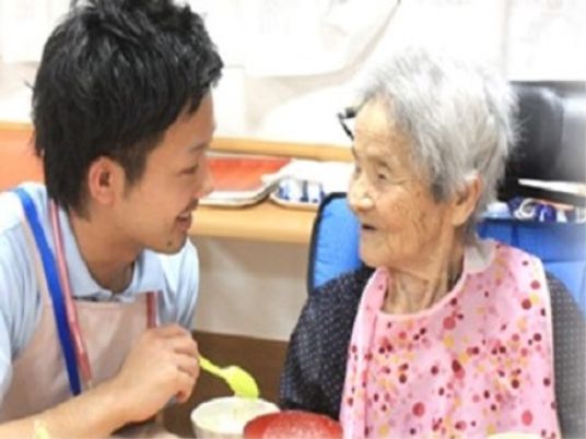 笑顔で食事介助するスタッフ