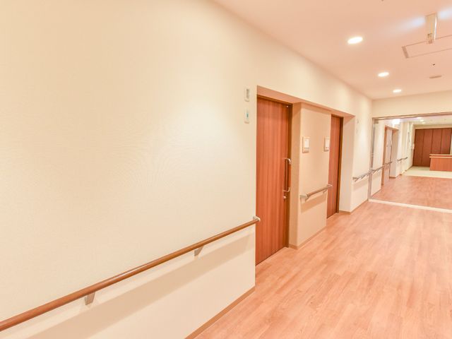 清潔な廊下と居室の扉 廊下 ゆったりとした廊下は明るく清潔感があり、各居室へのアクセスもスムーズです。従事する方にも快適な環境が広がっています。