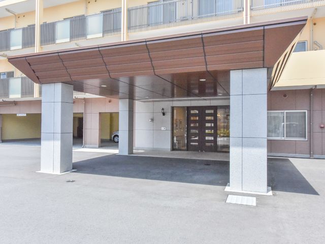明るい建物のエントランス 施設正面玄関 広々としたエントランスは、日当たりも良く、訪れる人を暖かく迎え入れます。ガラス扉を通して光が差し込み、開放的な雰囲気が感じられます。