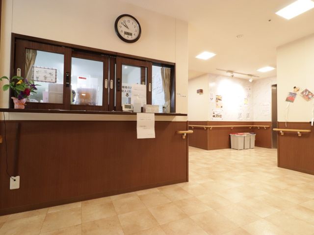 受付カウンターと情報掲示板 スタッフルーム あたたかみのある木目調の受付カウンターです。清潔感のある広々とした空間が訪れる方をお迎えします。