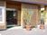 格子デザインが和な玄関には大きなガラスの自動ドアがある。玄関前には大きめの鉢に入った観葉植物が置いてある。