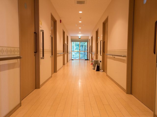 明るい廊下の手すり付き 通路 ゆったりと手すりが設置された廊下は、広々として明るい雰囲気です。安心して歩行訓練ができる環境が整っています。