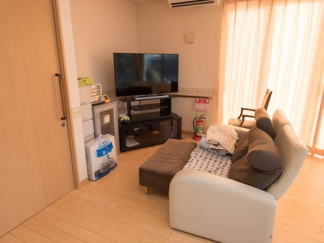 快適な居室のイメージ 共用スペース 広々として明るい居室は、ゆったりとくつろげる空間です。隅に設置された大型テレビが日々の憩いを提供します。