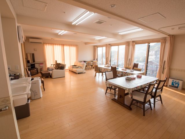 共有スペースの広々とした居室 食堂 広々とした居室は、落ち着いた色合いで統一されており、ゆったりとした時間を過ごせる空間となっています。機能的な家具配備も充実しており、快適な勤務環境が整っています。