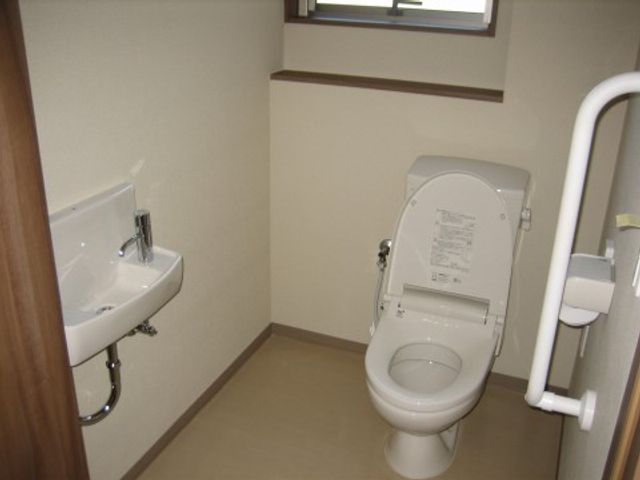 手すり付きトイレ空間 トイレ 手すりと広いスペースが配慮されたトイレです。利用者の安全と快適さを考えた設計で、支援がしやすくなっています。