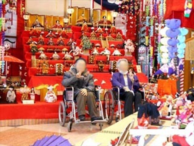多彩な飾り付けの共用スペース イベント（２） 笑顔でリラックスする二人の利用者が、鮮やかな装飾に囲まれた居心地の良いラウンジで特別な時を過ごしています。