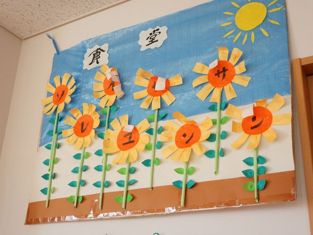 手作りひまわりの壁飾り 装飾 明るくあたたかな雰囲気を感じさせる壁の手作り飾りです。季節感を形にした活動が楽しめる環境が整っています。