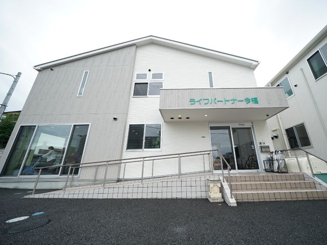 施設の清潔な外観 外観 バリアフリー設計の入り口が確認できる、清潔感のある建物です。明るい雰囲気の職場で、新しいキャリアを築きませんか。