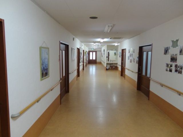 清潔な施設の廊下 廊下 ゆったりとした廊下は明るく、壁には絵や掲示物が飾られ、訪れる人々を暖かく迎え入れています。
