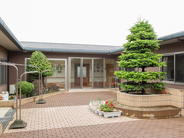 緑豊かな中庭エントランス 中庭 緑と植木に囲まれたエントランスは訪れる人に安らぎを提供しています。ゆったりとした空間が印象的です。