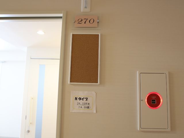 居室のドアと案内板 居室の入り口 居住者のプライバシーを重視した個室の入口です。安心のセキュリティと明確な部屋番号表示が確認できます。