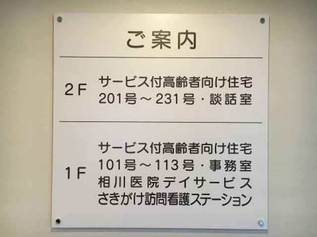 施設案内表記の掲示物 施設案内 明瞭な案内表示により、必要な場所へのアクセスが分かりやすくなっています。ドアの横に掲示された案内板が、目的の部屋やスペースへの道しるべになります。