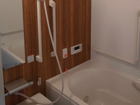 一般個浴タイプの浴室。安全性を考慮し、複数の手すりを設置している。急な体調の変化に対応できるようにナースコールを設けている。
