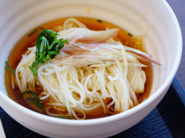 和風のつゆに入るめん類 季節に合わせた小鉢もあります 新鮮な薬味を添えた温かい麺料理は、心も体も温まる一品です。栄養バランスを考えた献立で、皆さんの健康をサポートいたします。