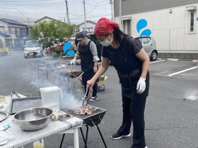 屋外でのバーベキュー風景 居室 手入れの行き届いた空間で、スタッフが楽しそうに食事の準備をしている様子です。