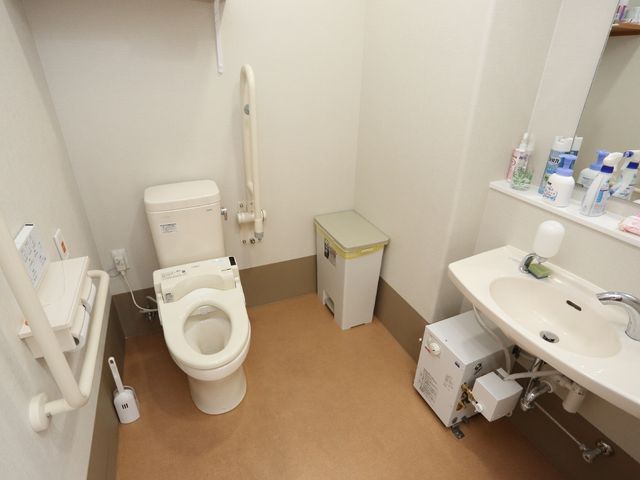 バリアフリートイレ設備 トイレ 手すりが備え付けられた清潔なトイレです。安全に配慮された構造で、ご高齢者の生活をサポートしています。