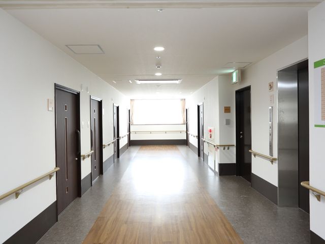 手すり付きの明るい廊下 廊下 手すりが設置された広々とした廊下です。壁には情報を掲示するボードもあり、従業員が円滑なコミュニケーションを取れる環境が整っています。