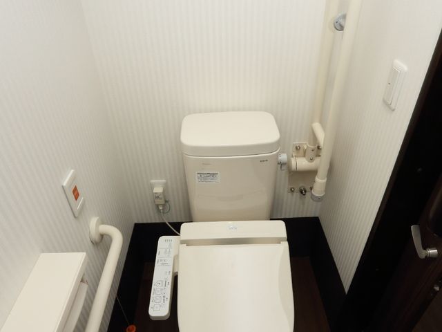バリアフリー対応のトイレ 居室トイレ 安全に配慮した手すり付きの清潔なトイレです。快適な利用を支える工夫がされています。