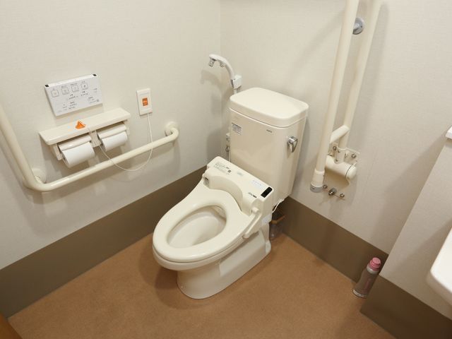 手すり付きの清潔なトイレ トイレ 安全に配慮されたトイレは手すりが設置され、利用者の自立を支援します。周囲は清潔に保たれ、快適な環境が整っています。