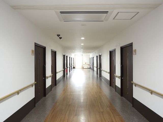 手すり付きの廊下 廊下 清潔で広々とした廊下は、手すりが設置され快適な移動が支援されています。扉も見やすい色合いでまとめられ、安心の環境です。