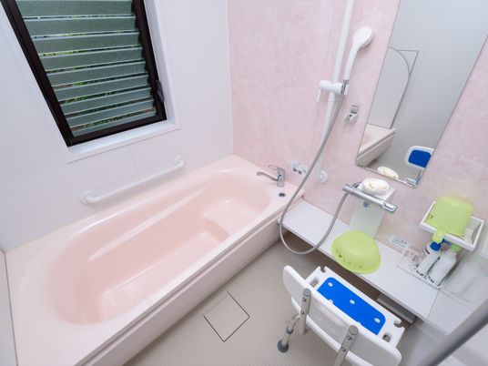 個室の浴室である。浴槽には腰を掛けられるスペースが確保されており、洗い場にはシャワーチェアや桶が用意されている。
