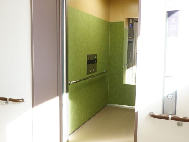 空間の広がる明るい廊下 エレベーター内の鏡 温かな日差しを取り入れた、ゆとりある通路が配されており、心地よい環境での仕事が期待できます。