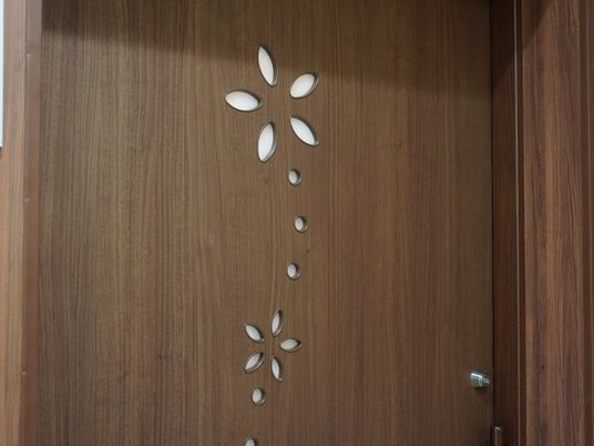 居室のドアはブラウンの木目調で壁と統一されている。鍵が付いていて、ドアの飾りとして花の模様が彫られている。
