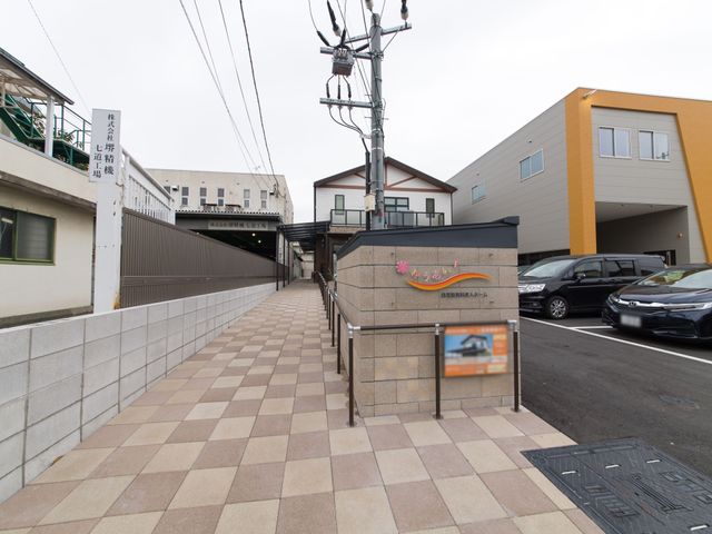 整備された施設の外観 入口 洗練されたデザインの建物前には、歩きやすいタイルが敷かれており、明るく開放的な環境が広がっています。