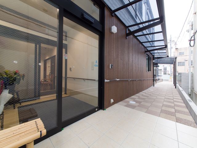 居室入口と廊下の様子 玄関 廊下は明るく、手すりが整った安全な通路です。清潔感のあふれるこの空間で、快適な勤務を実現できます。