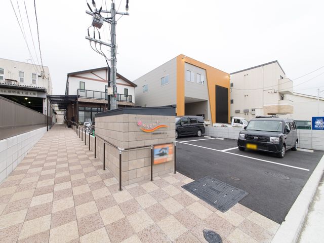 施設の明るい外観 入口 ゆったりとした駐車スペースと、落ち着いた色合いの建物が印象的な施設です。働く環境を大切にする方におすすめの場所です。