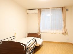明るい居室のベッドと窓