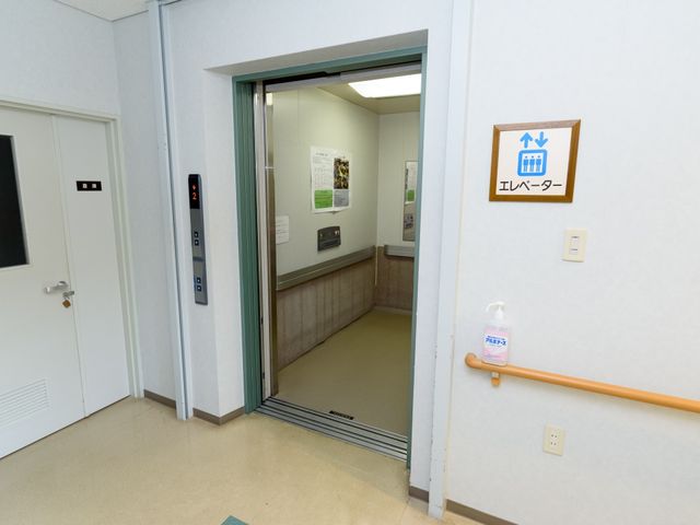 エレベーター周辺の通路 エレベータ 車椅子でも安心して移動できる広々としたエレベーターホールです。清潔感のあるバリアフリー設計が特徴です。