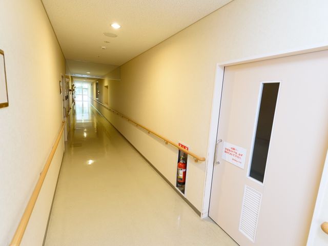 明るい廊下 通路 手すりが設置された温かみのある廊下です。安全に配慮しながら移動ができる環境が整っています。