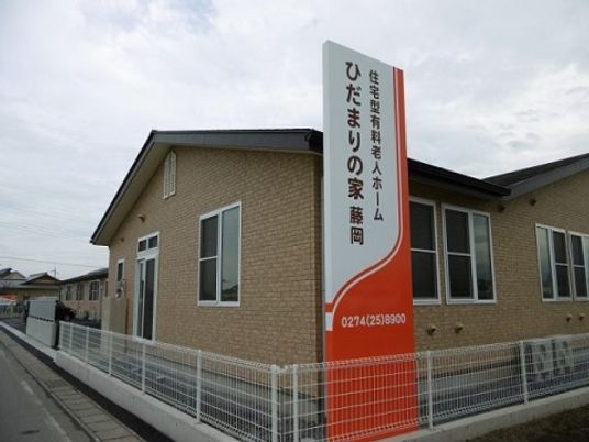 明るい外壁の建物と看板