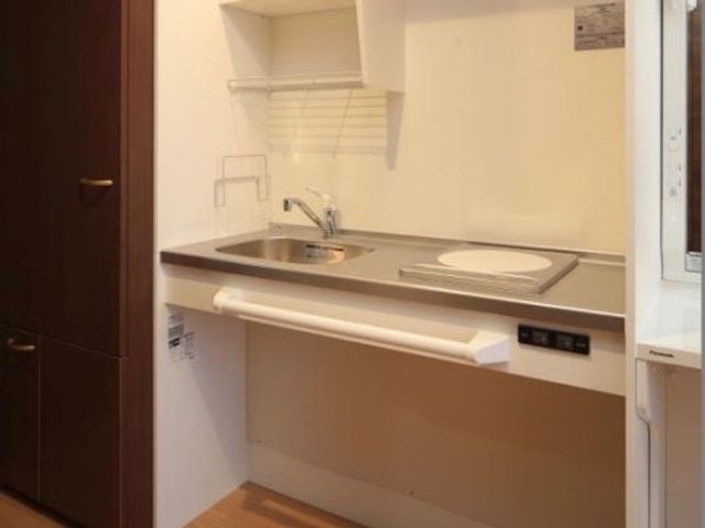 コンパクトな洋室キッチン 居室 使い勝手のよい小さなキッチンです。シンクや調理スペースが充実しており、日々の料理が快適にできる設計になっています。
