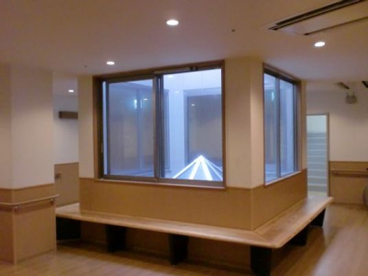 廊下の一角に設けたガラス張りで囲まれた四角形の空間の周りに腰かけ台を設置している。天井にはエアコンを完備している。