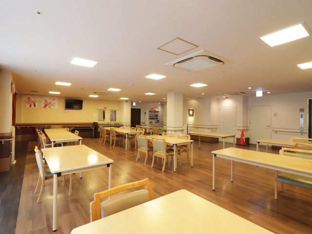 広々とした明るい食堂 リビング 広々とした清潔感のある食堂で、落ち着いた色合いの家具が配置されています。ゆったりとした雰囲気の中、利用者様が食事を楽しめる空間です。
