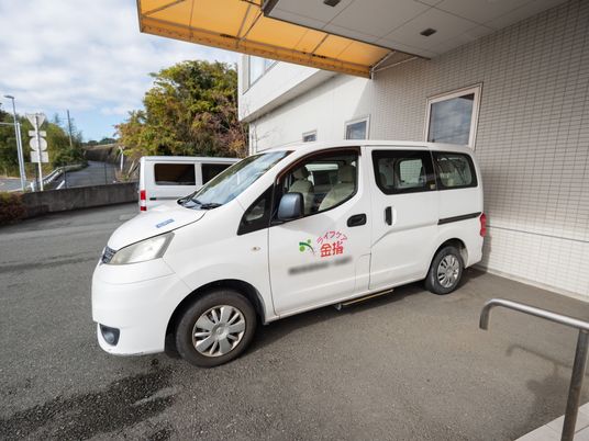 白い車両と建物外観