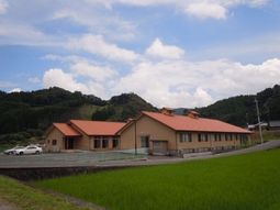 緑に囲まれた一階建て建物