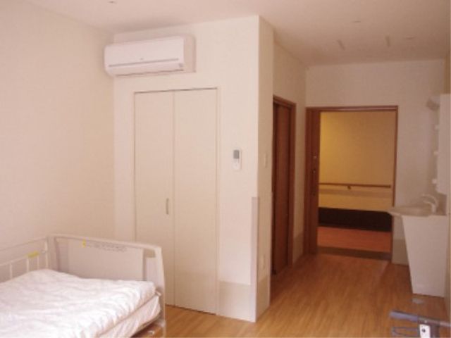 シンプルな居室の一角 居室 清潔感漂う居室は木目調で落ち着いた雰囲気です。手すりやバリアフリー設計により、安心してご利用いただけます。