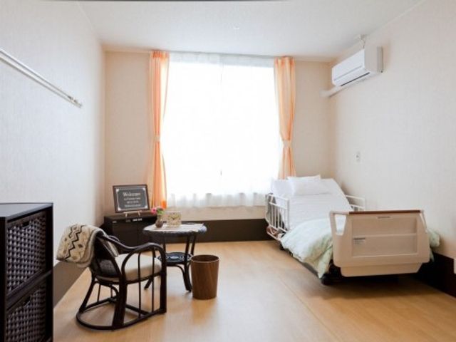 居心地の良い居室空間 居室 温かみのあるカーテンが特徴の居室です。日当たりが良好で、ゆったりとした椅子が配置され落ち着いた雰囲気を醸し出しています。
